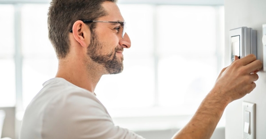 man setting thermostat